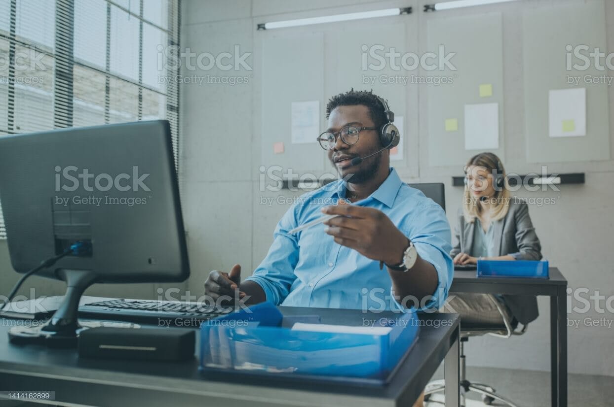 a man sitting at a desk with a computer in front of him