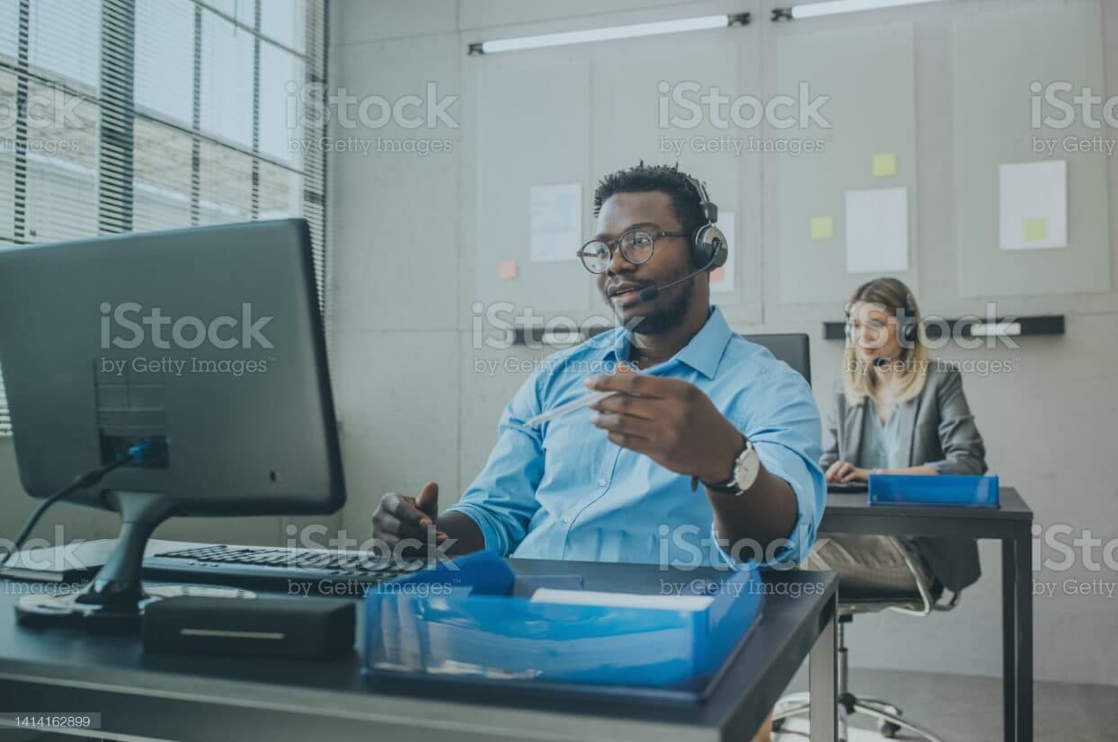 a man sitting at a desk with a computer in front of him