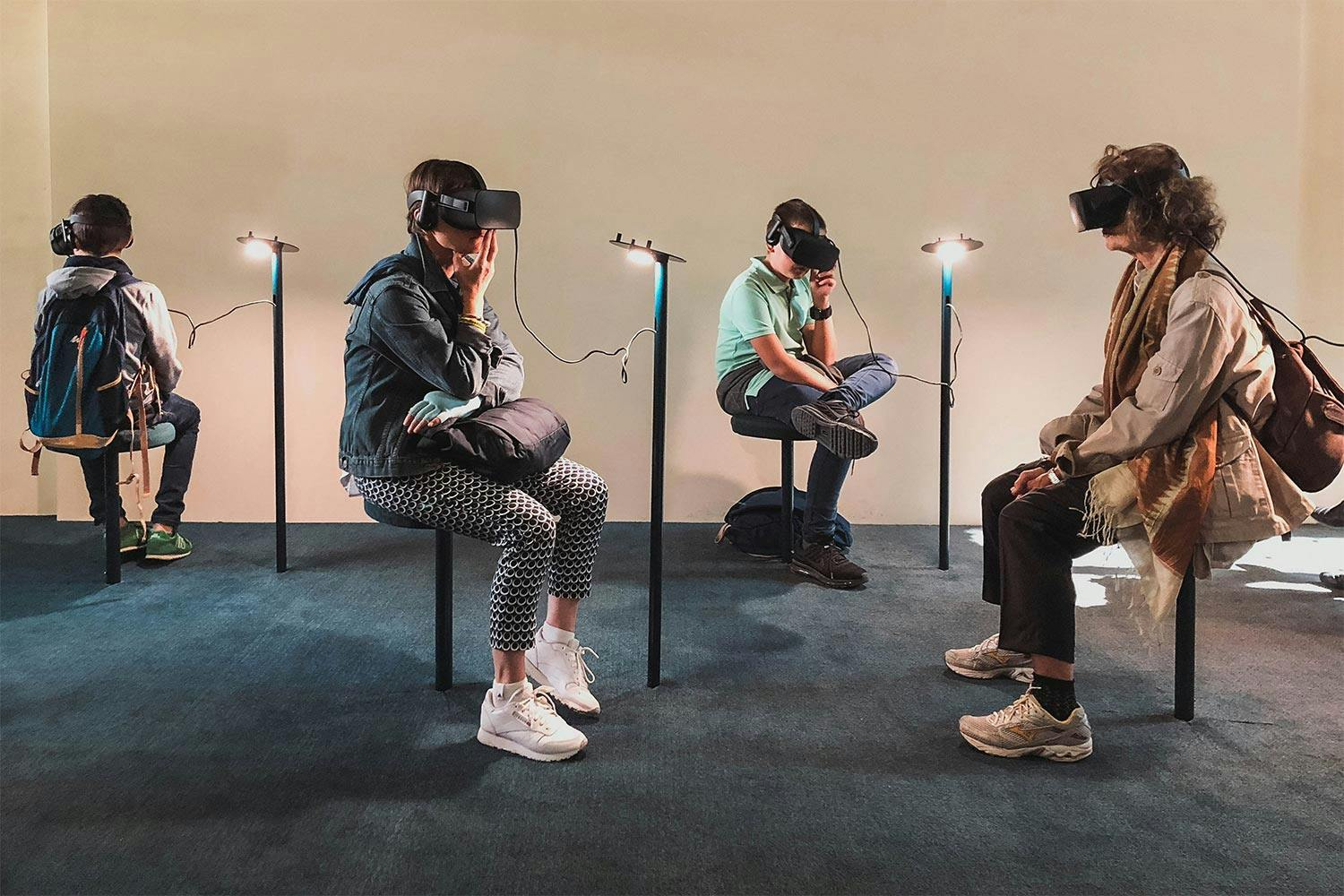 People sitting separately staring into VR equipment
